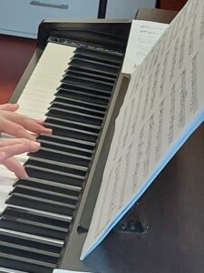 dłonie grające na pianinie elektrycznym