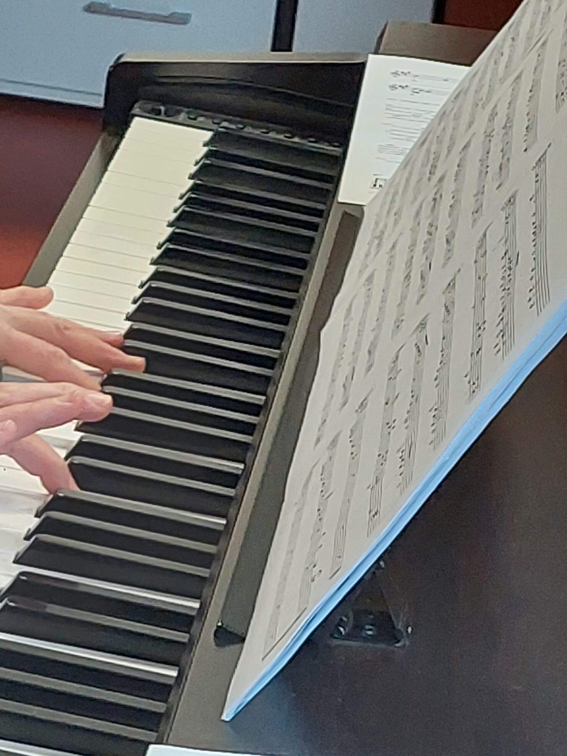 dłonie grające na pianinie elektrycznym