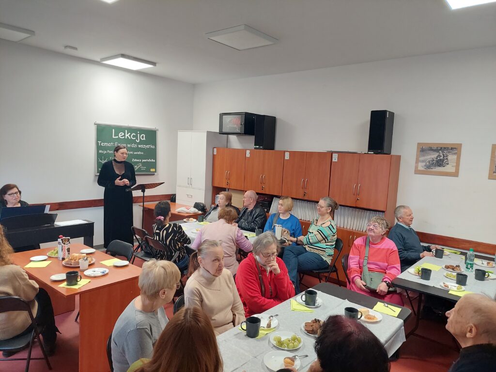 absolwenci słuchający występu aktorki Teatru Polskiego