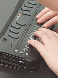 uczeń czytający brajla na monitorze brajlowskim