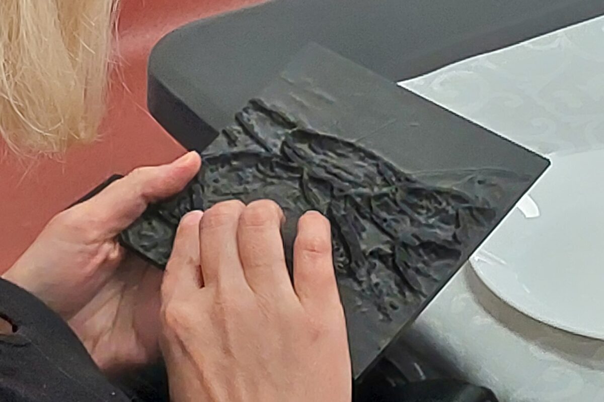 dłonie przesuwające się po makiecie wydm Puszczy Kampinoskiej